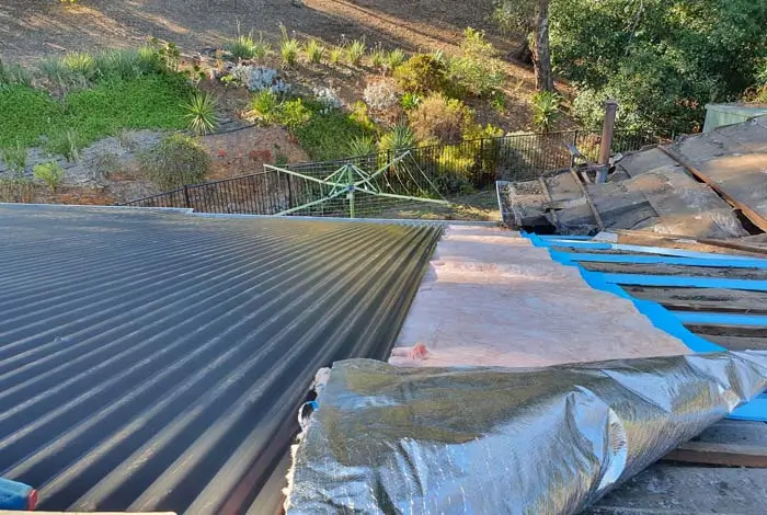Roofing Whangarei installs insulation and new sheets as part of a re-roofing upgrade.